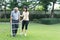 Asian girl daughter take care of disabled senior grandfather in garden. Attractive young woman help and support elderly older man
