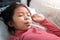 Asian girl with digital thermometer in her mouth on bed at morning time, Sick child with high fever  Selective focus, Healthy and