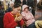 A asian girl is eating a hamburg for breakfast in Maria Reiche Neuman Airport in Peru. She and her friend look very tired.