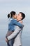 Asian girl and european guy kissing on background of sea