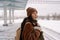 Asian girl going on winter journey feel cold waiting for train arrival outdoors at snowy station