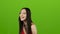 Asian girl is having fun and laughing loudly at her beautiful smile. Green screen