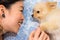 Asian girl and her cute dog staring into each other\'s eyes