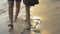 Asian girl with her sister walking hand in hand along together leisurely on the beach with waves washed up on the coast.