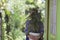 an Asian girl holding a Beautiful Caladium plant on white pot in the backyard