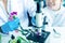Asian girl leaning and education with woman science lab research flower with microscope for Natural aromatic and essential oil fro