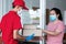 Asian girl with mask and safety gloves receiving delivery boxes from delivery man