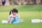 Asian girl is packing plastic bottle in bag. Children collect garbage to help maintain clean and beautiful environment.