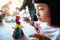 An Asian girl is painting plaster dolls with colored posters.