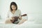 Asian girl Play the guitar from the morning wake up. Making it feel bright and soothing music can develop the brain and mind.