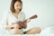 Asian girl Play the guitar from the morning wake up. Making it feel bright and soothing music can develop the brain and mind.