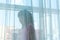 Asian girl playing behind the sheer curtain by big window with e