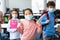 Asian girl pointing at her face mask standing in classroom