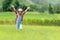 Asian girl raise arms and jumping on the green meadow outdoors adventure. People kid tourism  traveling education nature forest fo