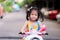 Asian girl riding an electric motorbike. Sweet smile, look at the camera. In the evening of the summer.