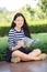 asian girl and school book in hand toothy smiling face with happiness emotion in green park