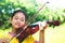 Asian girl standing with violin smiles happy.