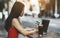 Asian girl in street cafe with laptop