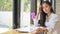 Asian girl student with study materials in a shared workspace,She looking at the camera and smiling