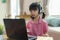 Asian girl student video conference e-learning with teacher and classmates on computer in living room at home. Homeschooling and