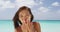 Asian girl walking on beach blowing kisses at camera having fun cute flirtatious