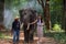 Asian girl walking with elephant and mahout in the forest. Tourism asian women holding camera in elephant village