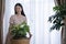 Asian girl Water the plants in house, this image can use for Calathea orbifolia