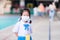 Asian girl wearing a white cloth mask to protect against the virus. She wore a school uniform, a blue skirt standing on a cement