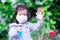 Asian girl wearing white medical face mask. Raise your hand as sign to stop others from getting close.