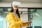 Asian girl wearing a yellow shirt, using VR headset. She is holding laptop and typing a keyboard