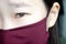 Asian girl wears a color protective medical mask. Coronavirus protection concept. Asian girl`s eyes. Fear will catch the disease.