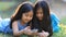 Asian girls playing a game on smart phone together