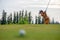 Asian golfer woman golf player hitting chips golf ball to the hole on the green.