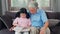 Asian grandfather relax at home. Senior Chinese, grandpa happy relax with young granddaughter girl enjoy read books and do