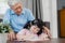 Asian grandfather teach granddaughter drawing and doing homework at home. Senior Chinese, grandpa happy relax with young girl