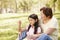 Asian grandmother and granddaughter blowing bubbles in park