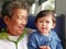 Asian grandmother laughing and smiling while enjoying holding her granddaughter as they traveling on a train together
