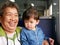Asian grandmother laughing and smiling while enjoying holding her granddaughter as they traveling on a train together