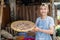 Asian grocer holding a woven bamboo tray filled with herbs