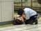 Asian guard on his knees helping a woman who fainted and is unconscious on the floor of the subway in Tokyo, Asia