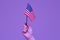 Asian hand holding the United States flag The purple background represents the color of gay people
