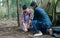 Asian handsome male and beautiful female pitching tent together while camping in forest on holiday vacation. Lifestyle, Couple and