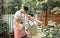 Asian handsome male LBGT couple wearing apron, sitting in outdoor garden together, doing activity as hobby in free time, helping,