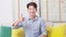 Asian handsome man looking at camera smile and showing thumbs up at home.Happy young smart businessman smile and confidence.