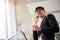 A asian handsome young businessman holding his hot coffee cup while using his phone and standing on the escalator. Business