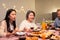 Asian happy big family enjoy spend time together celebrate holiday party, eat food and drink on dinner table at home. Loving