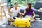 Asian happy cheerful excited male female husband and wife lover couple traveler sitting on carpet throwing raining US dollar money
