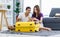 Asian happy cheerful male female husband and wife lover couple traveler sitting on carpet using mobile phone browsing surfing