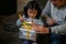 Asian Happy family with daughter in Santa hats gathered together on Christmas time and enjoy gifts box