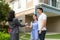 Asian happy smile young couple take keys new big house from real estate agent or realtor in front of their house after signing